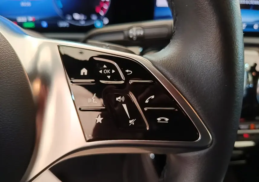 Gros plan sur les commandes tactiles noires à gauche du volant cuir de la Mercedes Classe A 250 e Business Line 2023.