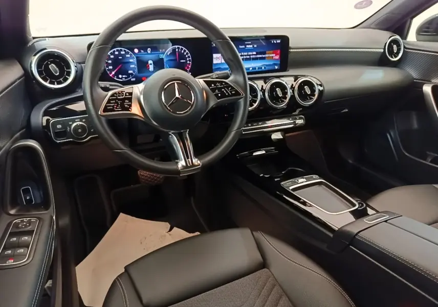 Vue intérieure de face du tableau de bord noir de la Mercedes Classe A 250 e avec écran tactile et volant multifonctions.