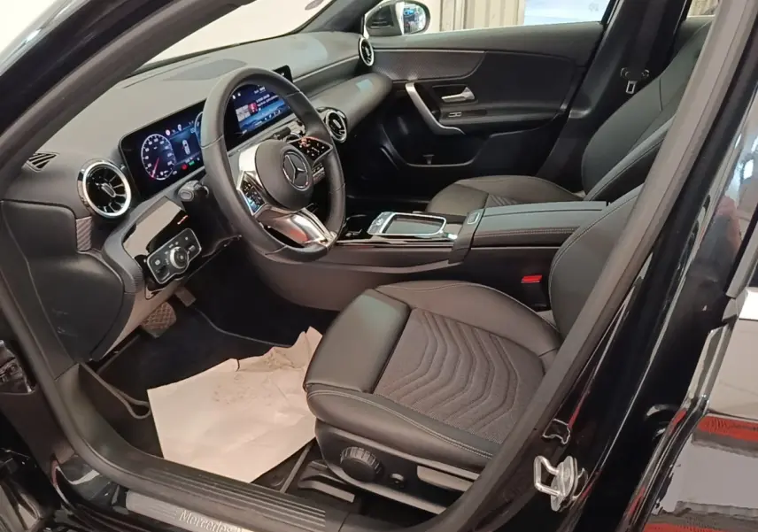 Intérieur noir de la Mercedes Classe A 250 e Business Line 2023, vue côté conducteur avec tableau de bord digital.