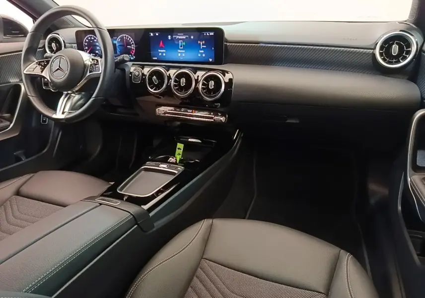Vue intérieure avant droite de la Mercedes Classe A 250 e noire, avec tableau de bord numérique et volant cuir multifonctions.