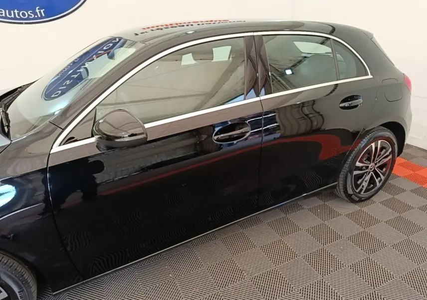 Vue de profil côté gauche d'une Mercedes Classe A 250 e Business Line noire avec jantes alliage et rétroviseurs électriques.