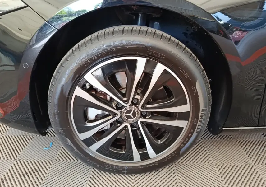 Gros plan sur la roue avant droite noire d’une Mercedes Classe A 250 e Business Line 2023 avec jante alliage bicolore.