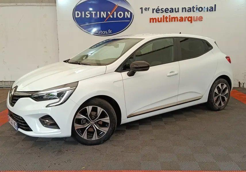 Renault Clio Evolution TCe 100 GPL blanche vue de profil droit en intérieur avec jantes alliage et rétroviseurs noirs.