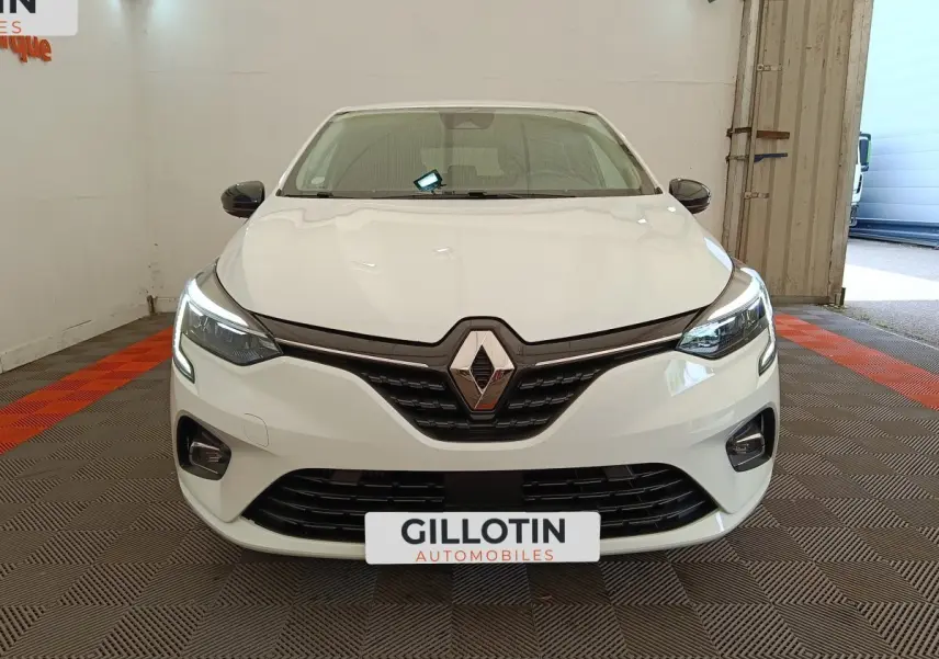Renault Clio Evolution TCe 100 GPL blanche vue de face, avec feux LED allumés et calandre noire brillante.