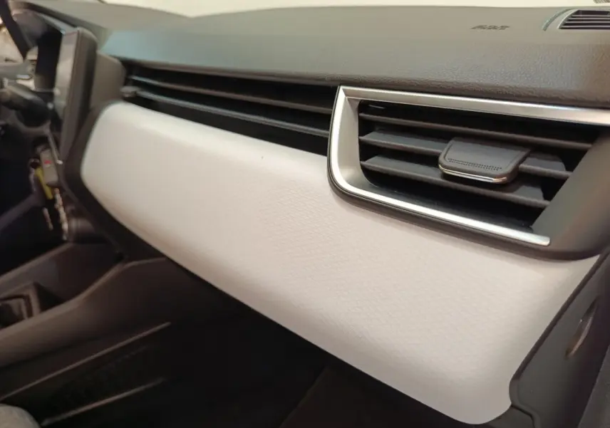 Détail intérieur du tableau de bord blanc et noir de la Renault Clio Evolution TCe 100 GPL 2023, côté passager.