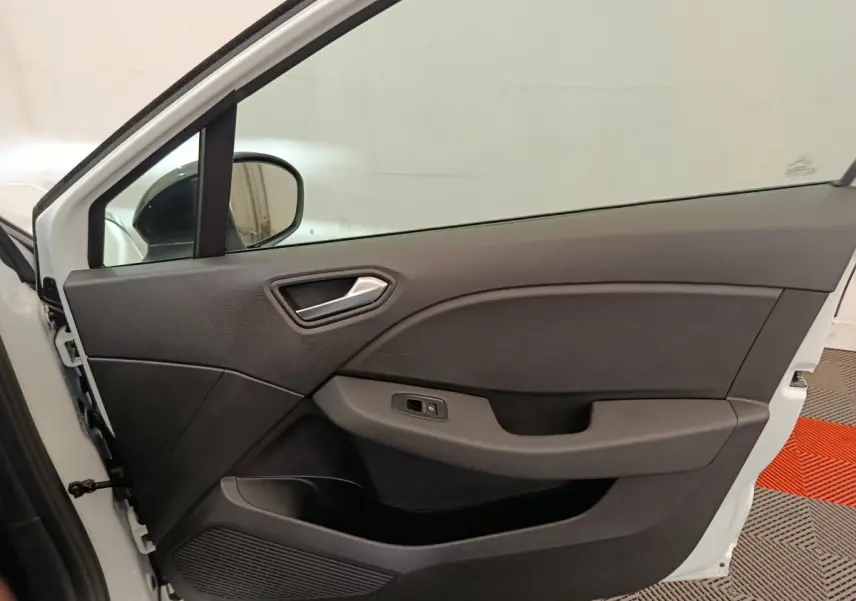 Vue intérieure de la porte avant gauche blanche d’une Renault Clio Evolution TCe 100 GPL 2023 avec poignée argentée.