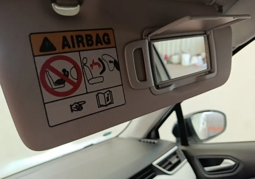 Vue intérieure côté passager avant de la Renault Clio blanche, avec pare-soleil déplié et miroir de courtoisie visible.