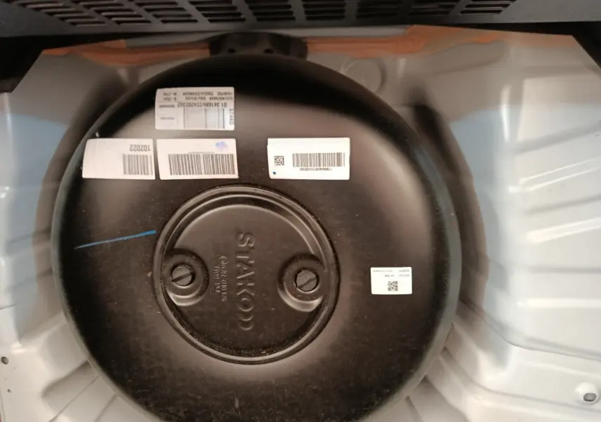 Vue rapprochée du réservoir GPL noir dans le coffre blanc d’une Renault Clio Evolution TCe 100 GPL 2023.