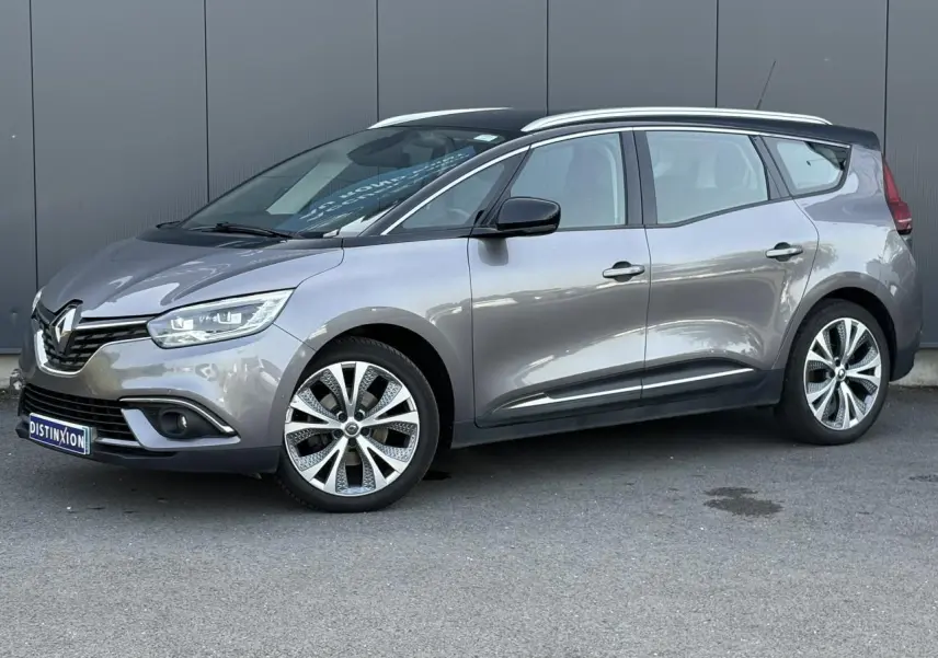 Renault Grand Scénic gris Cassiopée en vue 3/4 avant droit avec barres de toit chromées et jantes alliage 20 pouces.