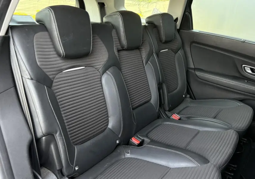 Vue latérale droite sur les sièges arrière en cuir noir avec surpiqûres blanches du Renault Grand Scenic IV 2021.