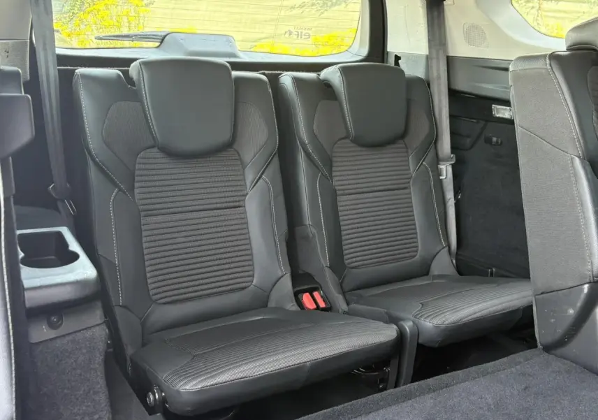 Vue intérieure arrière du Renault Grand Scenic IV 7 places, montrant les sièges en cuir noir avec surpiqûres blanches.