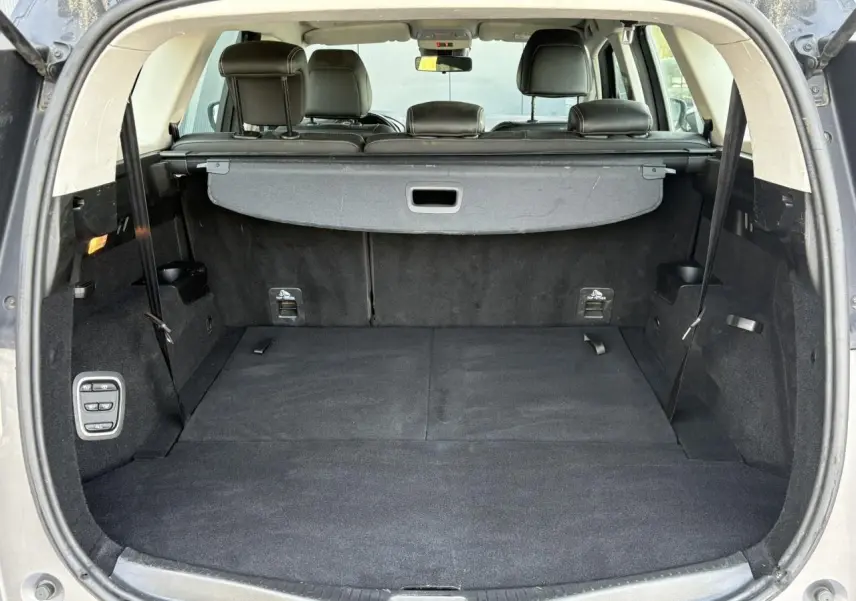 Coffre ouvert vu de l'arrière du Renault Grand Scenic gris Cassiopée, montrant l'espace et la banquette rabattue.
