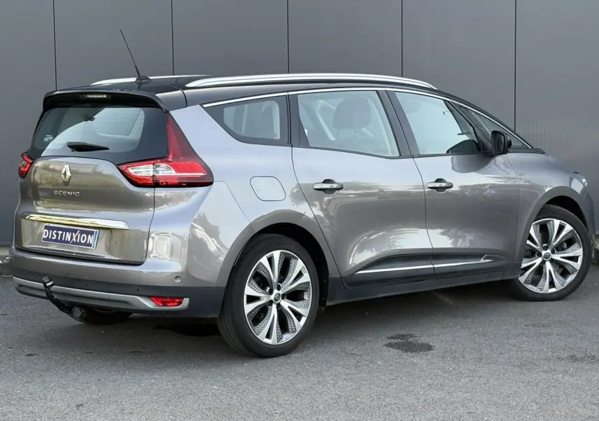 Vue 3/4 arrière droit du Renault Grand Scénic IV gris Cassiopée avec jantes alliage 20 pouces et attelage visible.