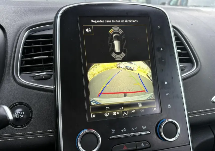 Vue rapprochée de l’écran tactile central du Renault Grand Scenic IV affichant la caméra de recul et l’aide au stationnement.