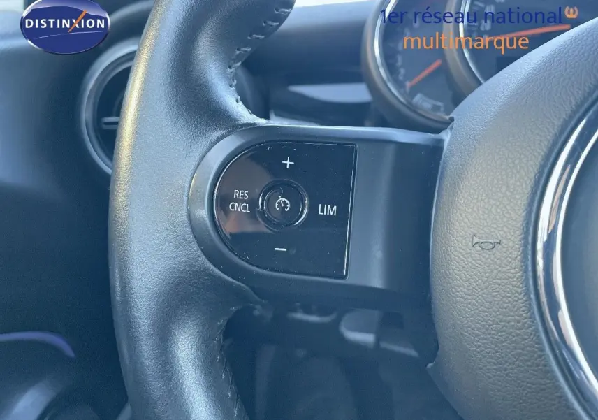 Gros plan sur le volant noir du MINI Cabriolet F57 2023, mettant en valeur les commandes de régulateur de vitesse.