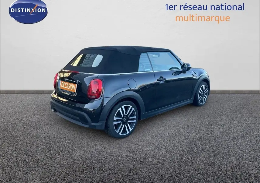 Vue 3/4 arrière droite d'une MINI Cabriolet F57 noire Midnight Metal avec capote fermée sur fond neutre.
