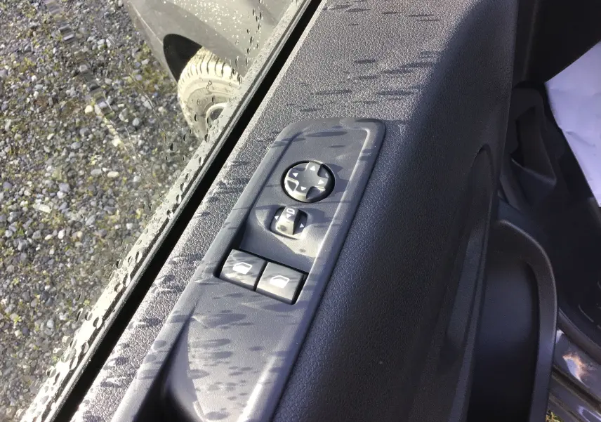 Gros plan sur les commandes des vitres et rétroviseurs côté gauche d'une Citroën Jumpy Cabine Approfondie gris titane.