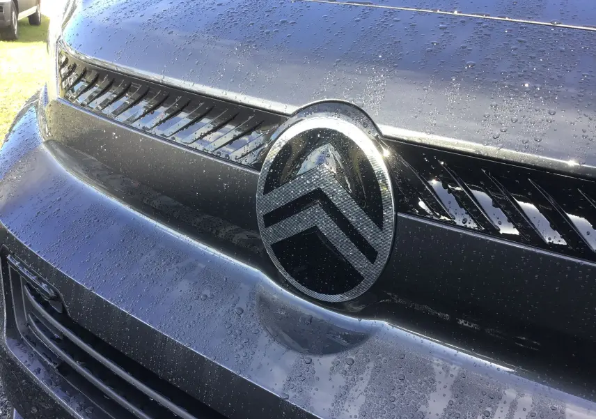 Gros plan sur la calandre gris titane du Citroën Jumpy XL avec logo double chevron et gouttes d'eau visibles.