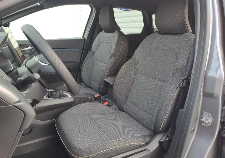 Vue intérieure côté gauche montrant les sièges avant gris foncé et le volant du Renault Symbioz Mild Hybrid 2025.