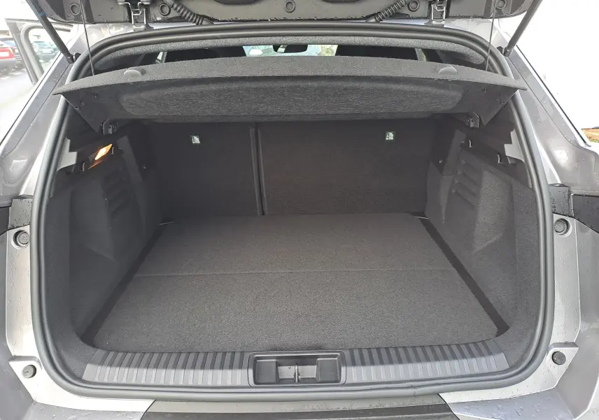 Coffre ouvert vu de l'arrière d'une Renault Symbioz gris Cassiopée, montrant un espace de chargement propre et spacieux.