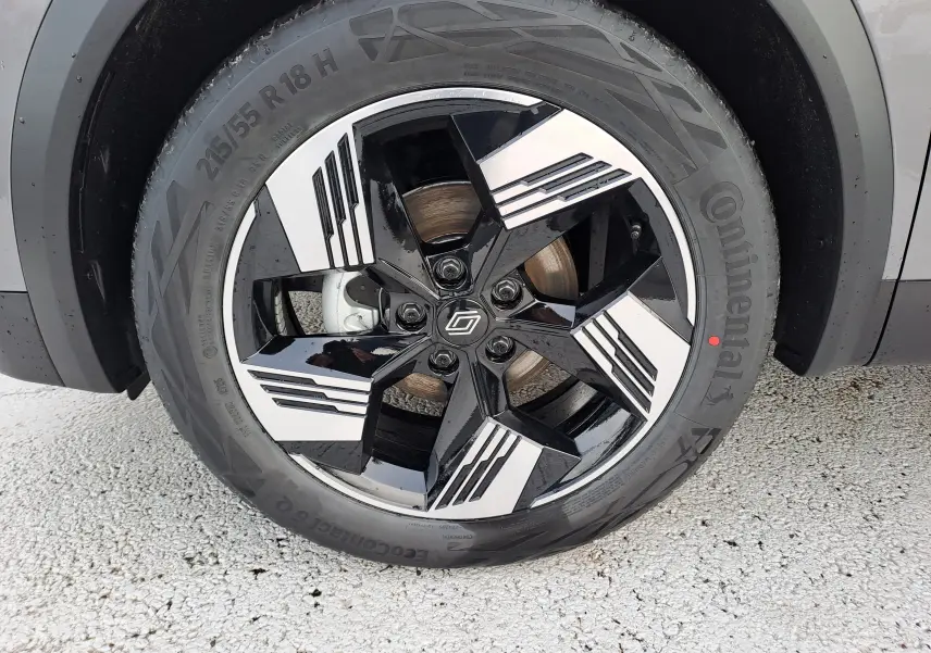 Gros plan sur la roue avant droite du Renault Symbioz gris Cassiopée avec jante noire et argentée au design géométrique.