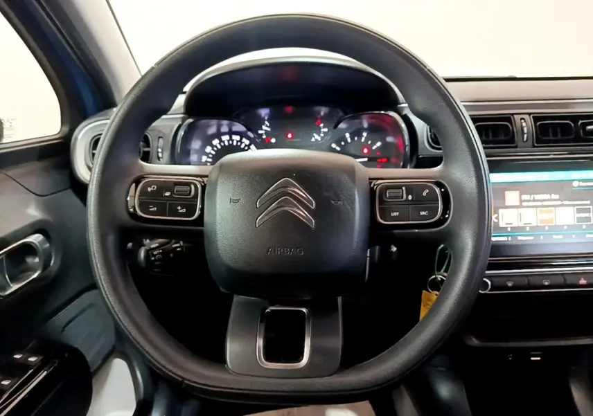 Vue rapprochée du volant multifonctions noir de la Citroën C3 2017 avec tableau de bord et écran tactile visible.
