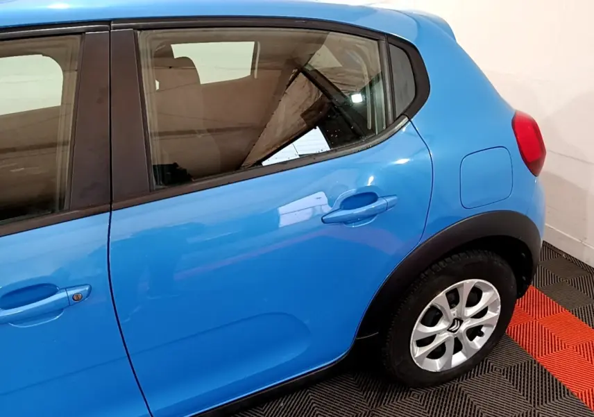 Vue latérale côté droit d'une Citroën C3 bleu vif, mettant en valeur la porte arrière et la roue avec jante argentée.