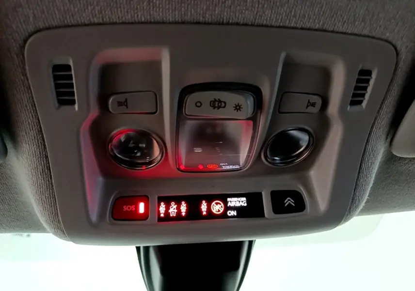 Panneau de commandes plafonnier intérieur avec voyants rouges et boutons d’éclairage dans une Citroën C3 bleu 2017.