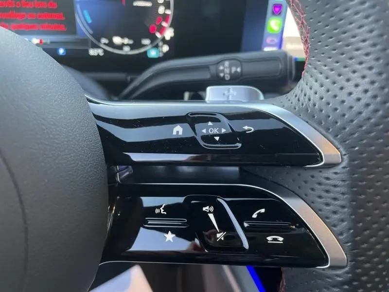 Gros plan sur les commandes multifonctions à droite du volant perforé du Mercedes GLA 250 e gris foncé métal 2025.