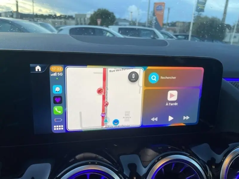 Écran tactile central du Mercedes GLA 250 e 2025 affichant la navigation, avec tableau de bord noir et aérateurs chromés.