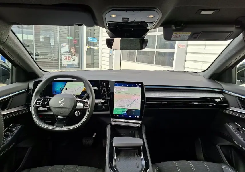 Vue intérieure avant du Renault Austral E-Tech Full Hybrid 2025, tableau de bord moderne avec écran tactile vertical et volant multifonction.