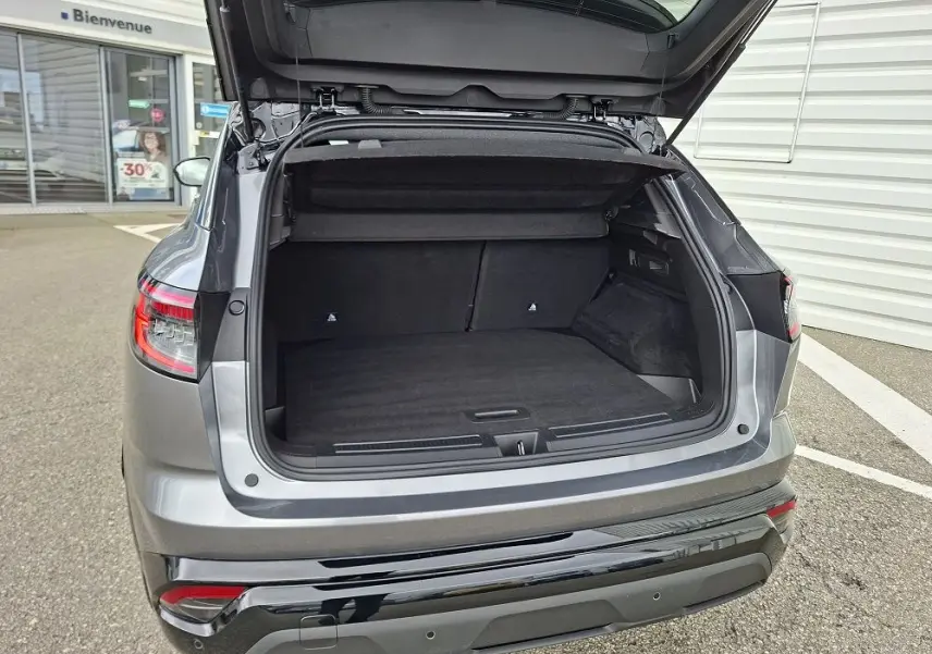 Coffre ouvert vu de l’arrière d’un Renault Austral gris schiste, montrant l’espace de chargement vide et le hayon relevé.