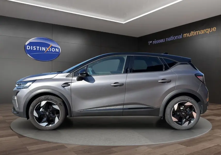 Profil droit du Renault Captur TCE 90 Techno 2024 gris Cassiopée avec toit noir et jantes bi-ton distinctives.