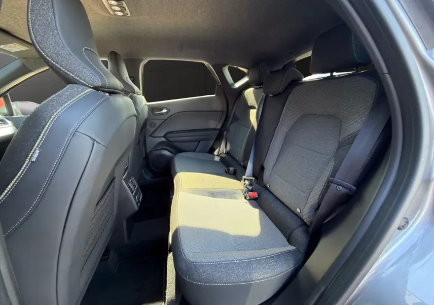 Vue intérieure arrière côté droit du Renault Captur 2024, sièges tissu noir avec surpiqûres blanches, portières gris cassiopée.