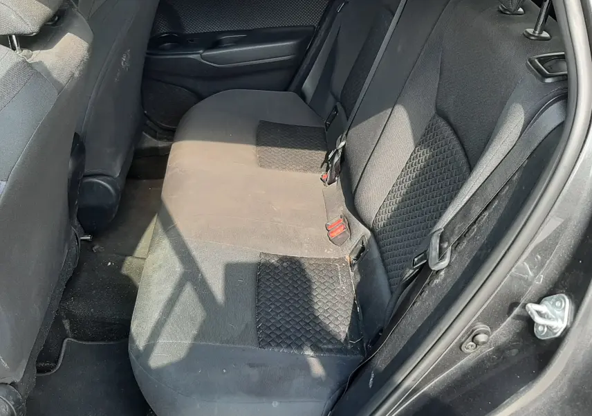 Vue intérieure côté droit des sièges arrière en tissu gris foncé du Toyota C-HR 1.8 Hybrid 2021, porte ouverte.