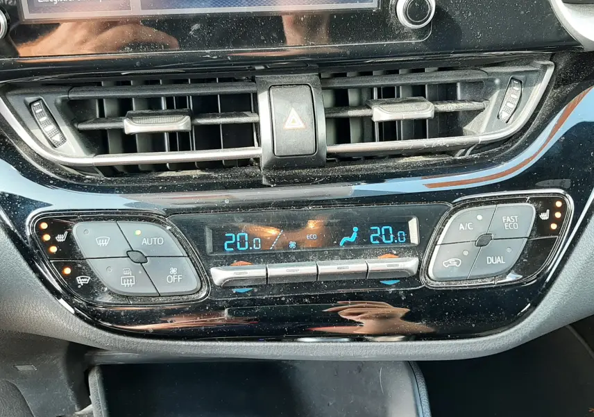 Vue rapprochée de la console centrale du Toyota C-HR gris atlas métal 2021, affichant la climatisation digitale et les commandes tactiles.