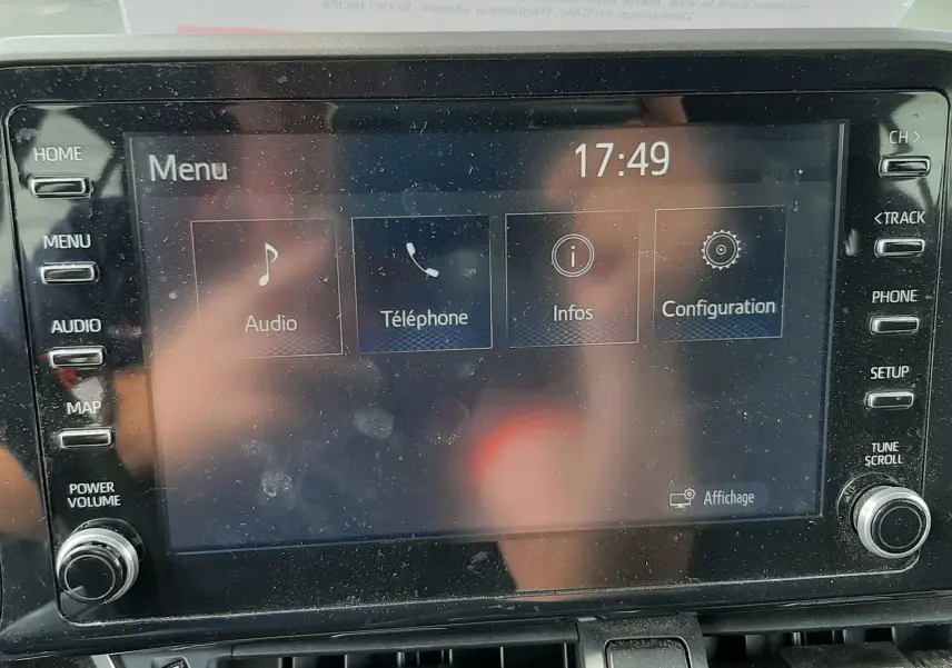 Vue intérieure centrée sur l’écran tactile multimédia du Toyota C-HR gris atlas, avec commandes et ventilation visibles.