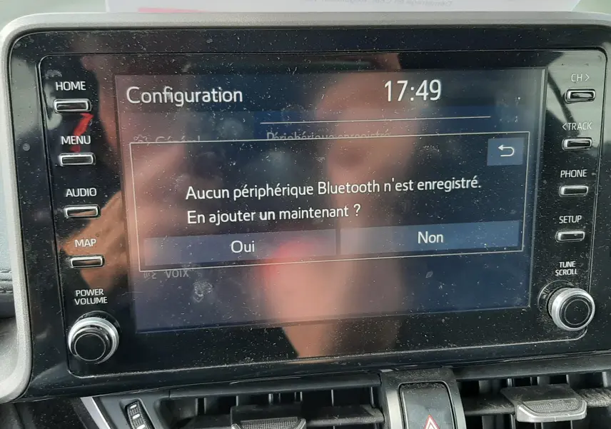 Écran tactile central du Toyota C-HR 1.8 Hybrid 2021 affichant un message Bluetooth, avec commandes autour et tableau de bord gris.