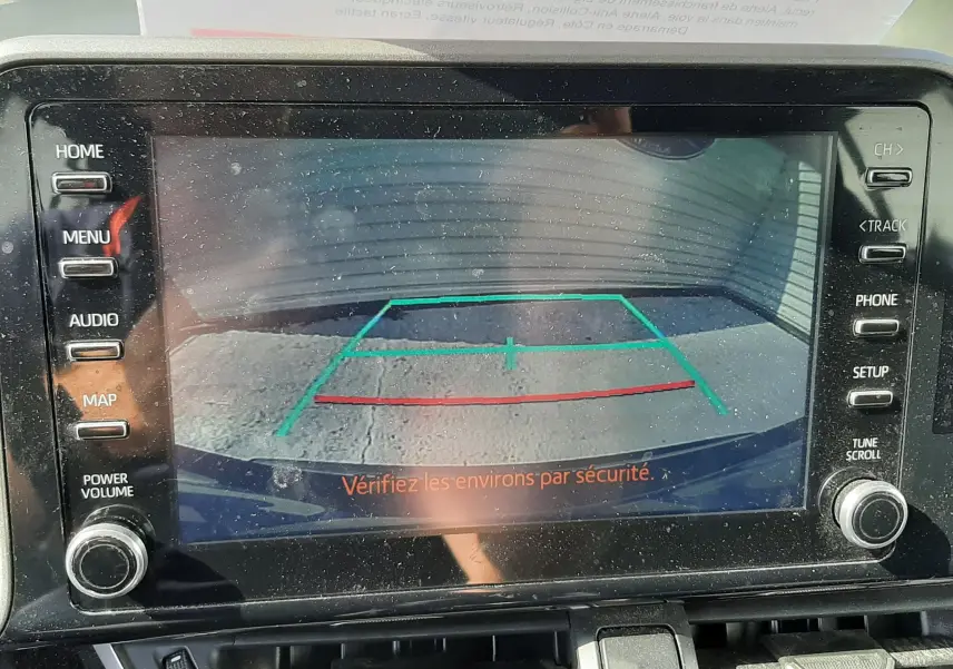 Écran multimédia affichant la caméra de recul du Toyota C-HR gris atlas, avec les lignes d’aide au stationnement visibles.