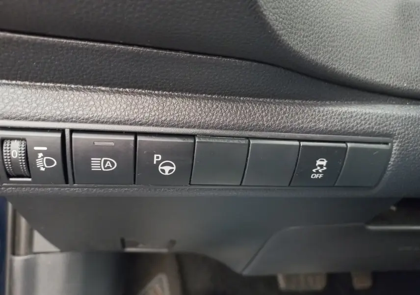 Gros plan sur les boutons de commande noirs du tableau de bord intérieur de la Toyota Corolla hybride 2022.
