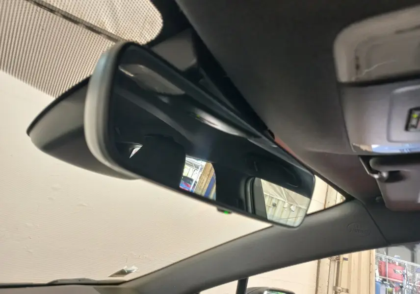 Rétroviseur intérieur de la Toyota Corolla hybride 2022, vue rapprochée de l'habitacle avec reflet du siège et fenêtre.