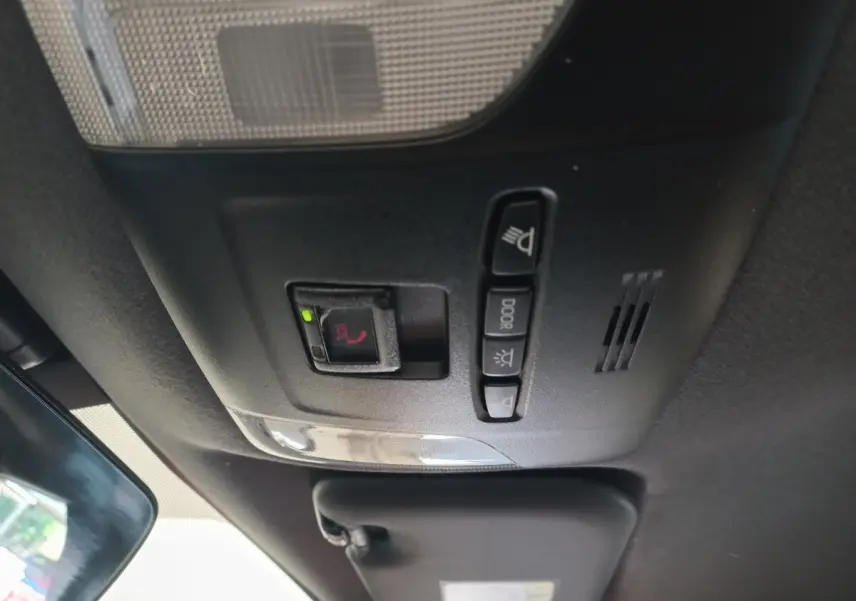 Vue intérieure du plafonnier avec commandes d'éclairage et bouton SOS dans une Toyota Corolla hybride bleue 2022.