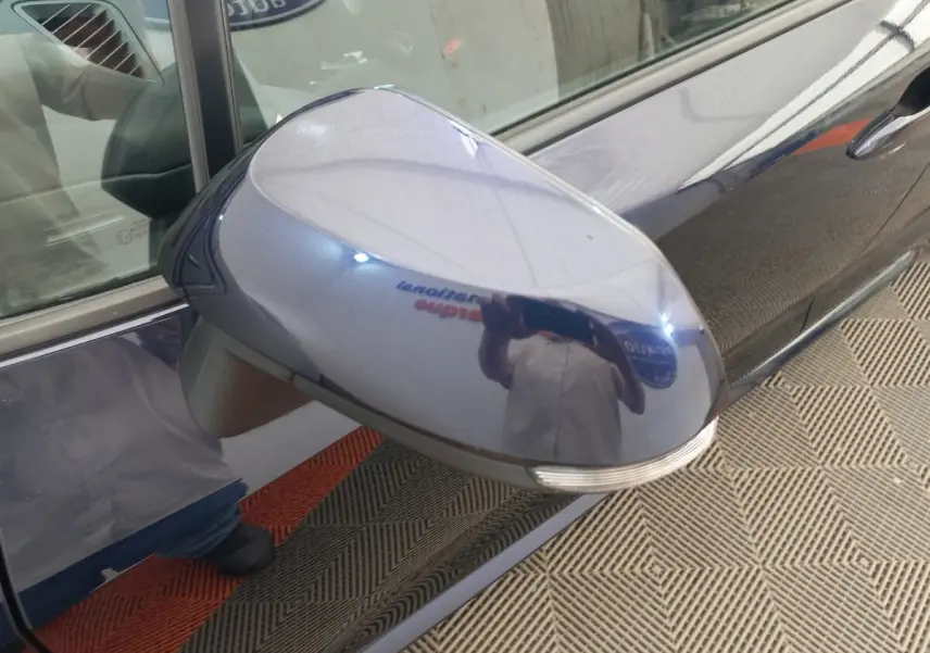 Rétroviseur côté gauche bleu brillant de la Toyota Corolla Hybride 2022 avec clignotant intégré, vue rapprochée.