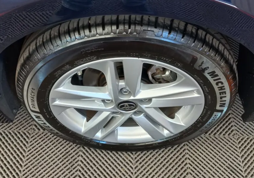 Gros plan sur la roue avant droite de la Toyota Corolla hybride bleue, avec jante argentée et pneu Michelin.