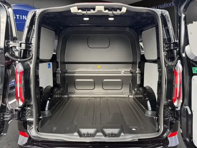 Vue arrière ouverte du Ford Transit Fourgon noir 2026, montrant l'espace de chargement vide et la cloison pleine.