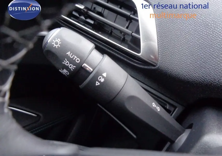 Gros plan sur la commande des feux et clignotants dans l'habitacle noir du Peugeot 3008 2023.