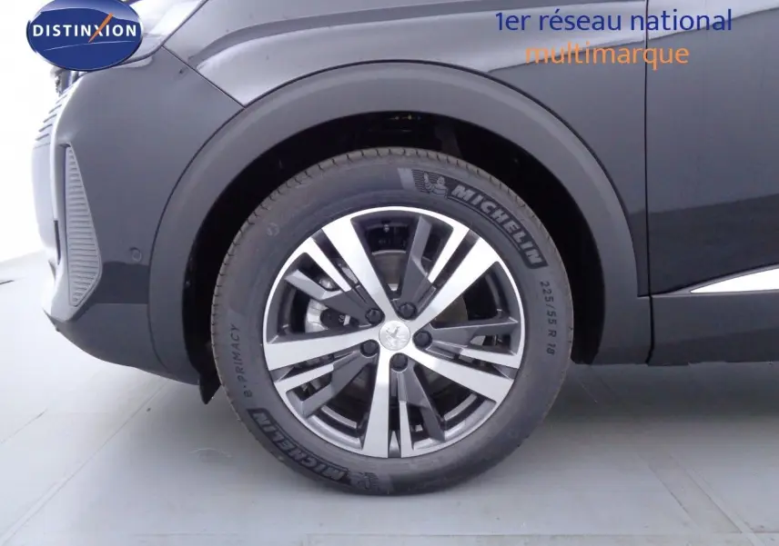 Gros plan sur la roue avant gauche du Peugeot 3008 noir Perla Metal avec jante alliage bicolore et pneu Michelin.