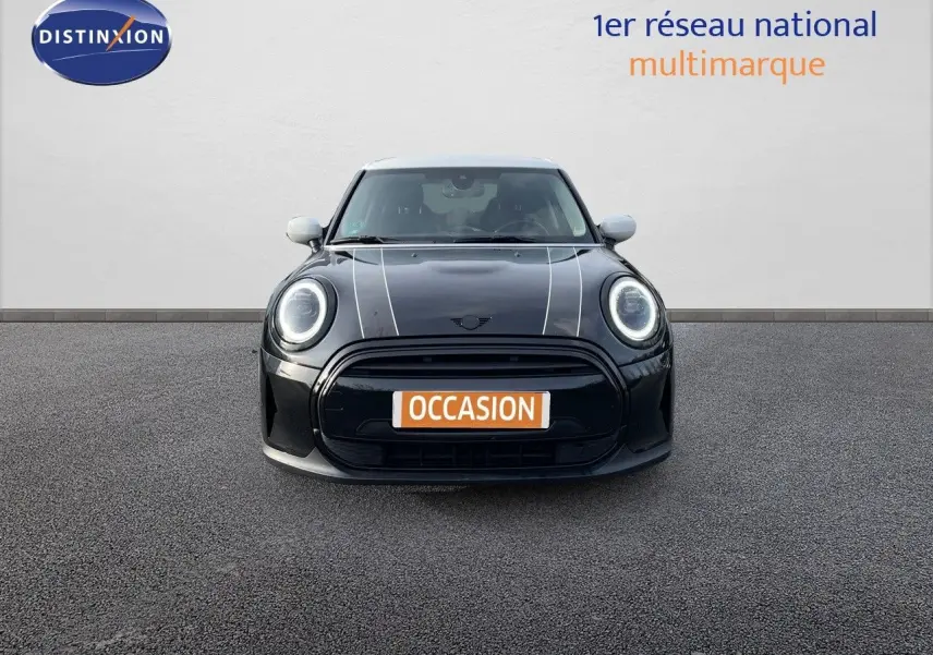 Vue frontale d'une MINI noire Midnight Metal avec bandes blanches sur le capot et rétroviseurs blancs.