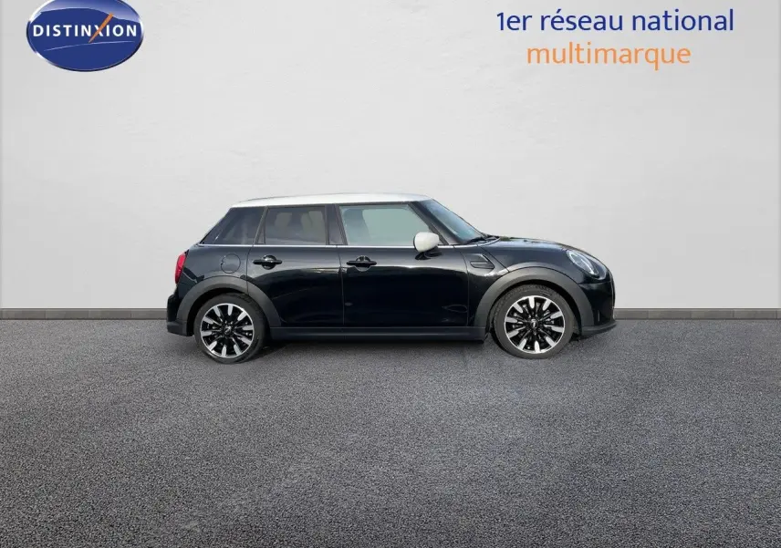 Vue de profil droit d'une MINI 1.5 136CH noire Midnight Metal avec toit blanc et jantes bi-ton, sur fond neutre.