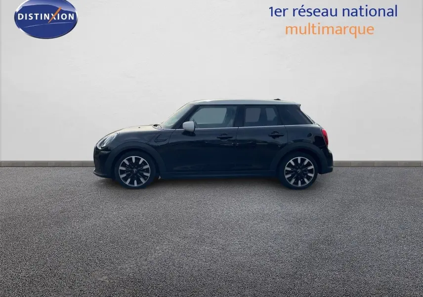 Profil droit d'une MINI 1.5 136CH STEPTRONIC noire Midnight Metal avec toit blanc et jantes bi-ton 17 pouces.
